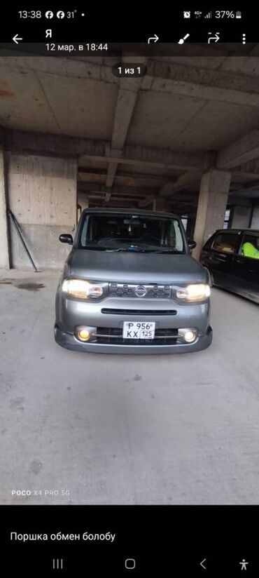 жели манжаро: Серый минивэн Nissan Cube, подходящий для комфортной езды по городу и