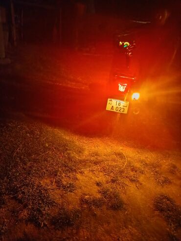 Arxa tərəfdən görünən qırmızı motosiklet. Fərqli görünüşü və praktik