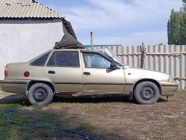 домкраты на авто: Седан Daewoo Nexia бежевого цвета с четырьмя дверьми и тонированными
