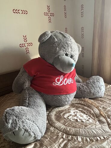Böyük boz rəngli oyuncaq ayı, üzərində "Love" yazısı olan qırmızı