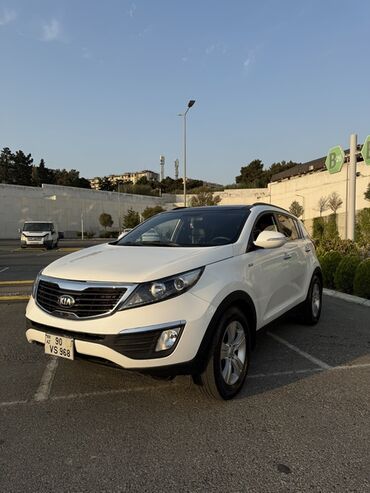 Kia Sportage modeli, ağ rəngdə, SUV tipli avtomobildir. Qara damı və