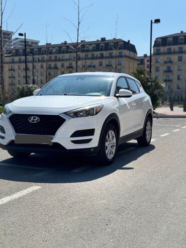 тап аз авто: Ağ rəngdə olan Hyundai Tucson krossoveri. Avtomobil şəhər və