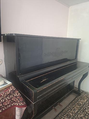 piano az: Qara rəngli, klassik üslubda akustik pianino. Korpus üzərində — 3