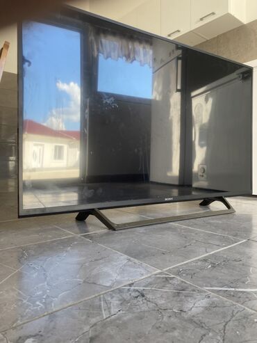Sony televizor crne boje sa tankim okvirom i postoljem koje omogućava