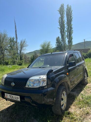 Nissan: Nissan X-Trail черного цвета. Этот внедорожник имеет рейлинги на крыше