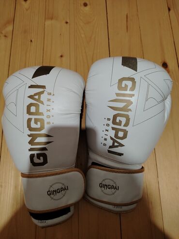 Nərdlər: Ağ rəngdə "GINGPAI BOXING" brendinin boks əlcəkləri, məşq və ya döyüş
