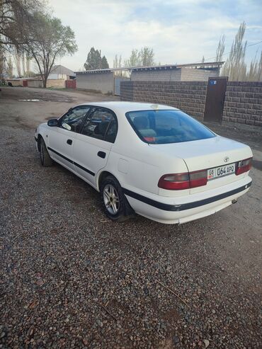 краска для автомобилей: Белый седан Toyota Carina Автомобиль оснащен четырьмя дверями, что