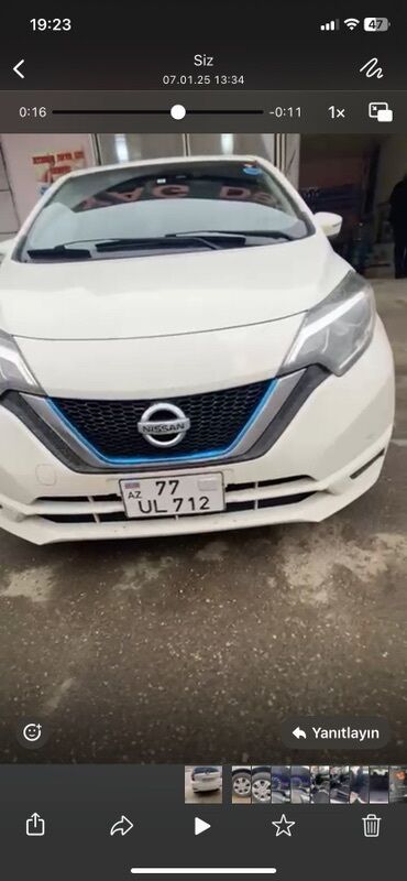 kvadrasikl satisi: Ağ rəngli, müasir dizaynlı Nissan avtomobili. Ön hissədə mavi