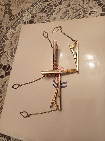 qizil sat: Zəncirli, qızılı rəngli metal qalstuk sancaqları. Bu dəstə bir neçə — 5