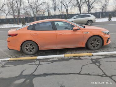 киа машына: Автомобиль Kia K5 оранжевого цвета, седан. Модель имеет современный