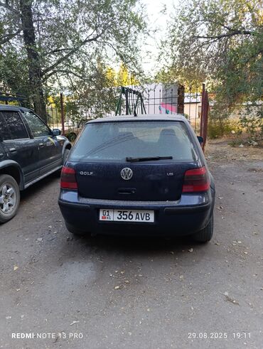 эмблема авто: Хэтчбек Volkswagen Golf синего цвета. Автомобиль оснащен четырьмя