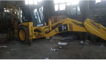 Ekskavatorlar: Komatsu markasına aid sarı rəngli WB 93 model ekskavator yükləyici. Bu