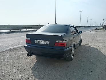 BMW: BMW E36 sedan kuzalı avtomobil. Tünd göy rəngdədir və klassik BMW — 8