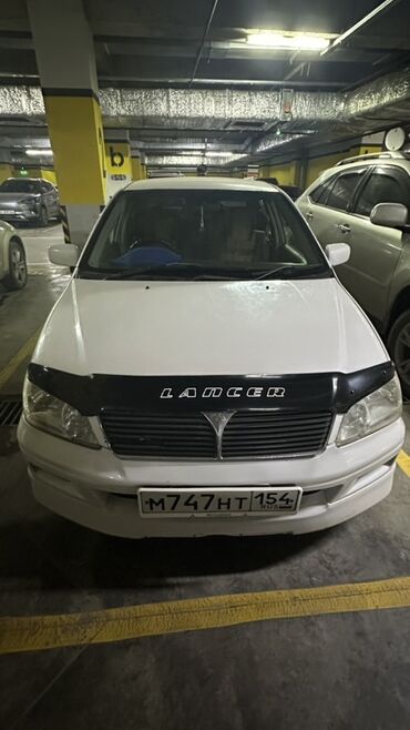 запчасти на митсубиси лансер 9: Белый седан Mitsubishi Lancer, оснащенный черной защитой капота для