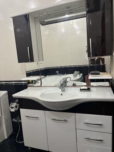 Unitaz baçokları: Ağ rəngli keramika lavabosu olan, qara və ağ rənglərdə hamam mebeli