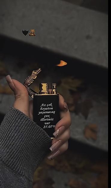 caxmaq: Qara, metalik detallı benzinli qızdırıcı alışqan. Qapaq hissəsi — 1