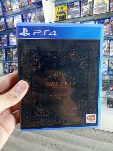 Oyun diskləri və kartricləri: PS4 üçün "Dark Souls Remastered" oyunu. Qara rəngli, üzərində qızılı