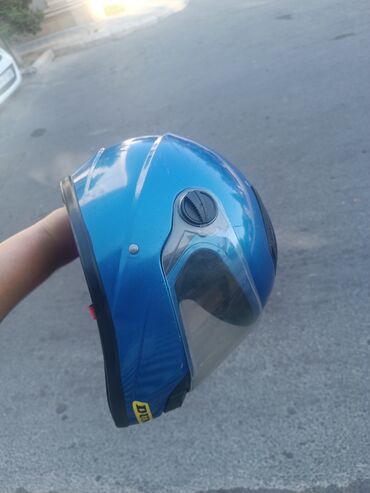 Şəffaf vizorlu mavi motosiklet dəbilqəsi. Sürüş zamanı başın