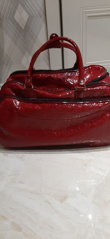 Çamadanlar: Parlaq qırmızı rəngdə, dəbli görünüşlü çantası. Qısa tutacaqları var — 7