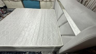 шкафы для хранение вещей: Кровать с мягким изголовьем и матрасом, выполненная в светло-сером