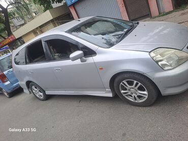 Honda: Автомобиль Honda Stream серебристого цвета. На сиденьях установлены