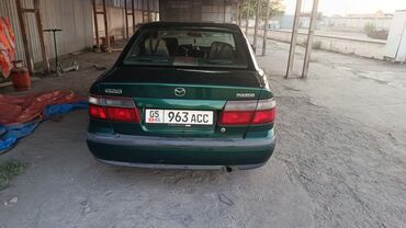 мазда трибуте: Mazda 626 седан, темно‑зеленый цвет. Кыргызские номера (KG), шильдики