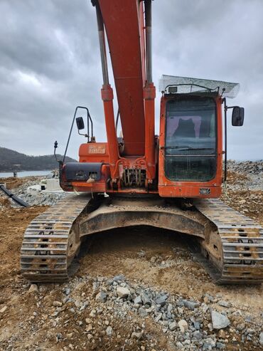 разбор экскаватора: Экскаватор Doosan DX300LC, выполненный в оранжевом цвете, предназначен