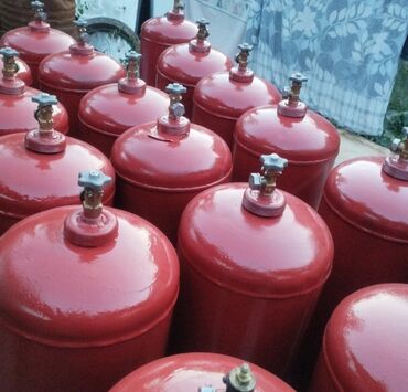 газовое оборудование пропан: Партия газовых баллонов красного цвета, предназначенных для хранения и