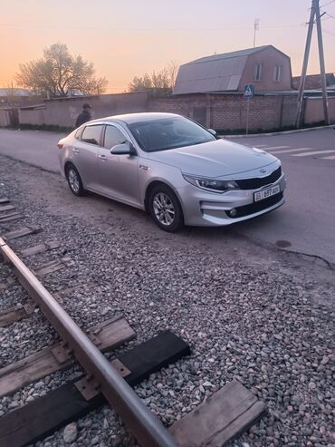 машина кейж: Kia Optima, серебристый седан. Основные особенности: - Кузов
