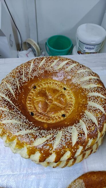 Выпечка, хлебобулочные изделия: Свежеиспеченный узбекский хлеб круглой формы, украшенный характерными — 8