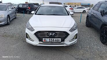 Hyundai: Белый седан Hyundai Sonata. Автомобиль отличается элегантным дизайном