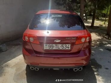 Kasalar: Arxa hissədən görünən tünd qırmızı rəngli Chevrolet Lacetti avtomobil
