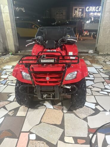детский мотоцикл на бензине: Красный квадроцикл Suzuki Eiger 400 4x4, предназначенный для