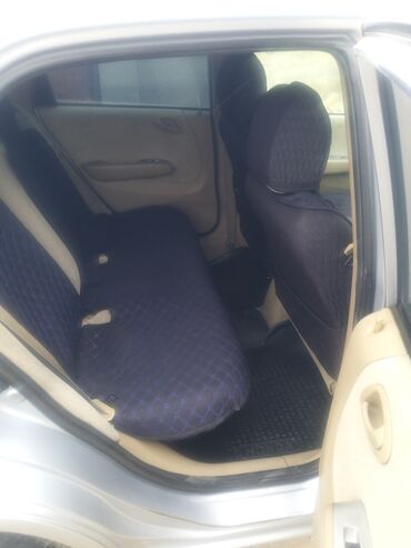 продаю машину в рассрочку: Автомобиль Honda City серебристого цвета. Салон обит чехлами синего