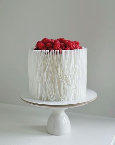 Tortlar: Zərif dizaynlı, ağ rəngli tort. Tortun ətrafı dalğalı bəzəklərlə əhatə — 3