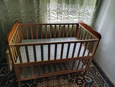 Детские односпальные кровати: Деревянная детская кроватка с реечными бортиками. Оснащена матрасом с