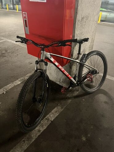 Trek markalı, gümüşü rəngdə dağ velosipedi. Qırmızı və qara rəng