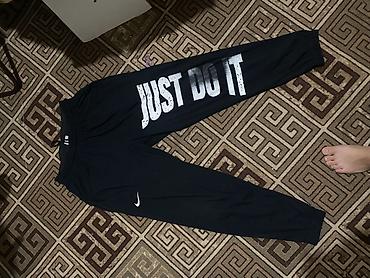 Спортивные штаны черного цвета с крупным принтом JUST DO IT на правой