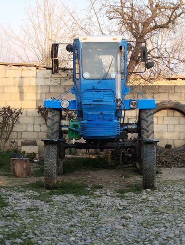 Traktorlar: Mavi rəngdə, dörd təkərli traktor. Kənd təsərrüfatı işləri üçün