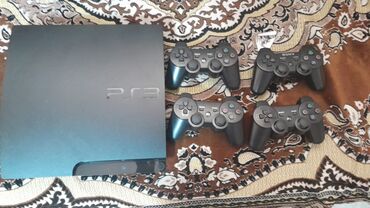 playstation 3 oyun yazilmasi: Qara rəngdə olan Sony PlayStation 3 oyun konsolu. Komplektə dörd ədəd