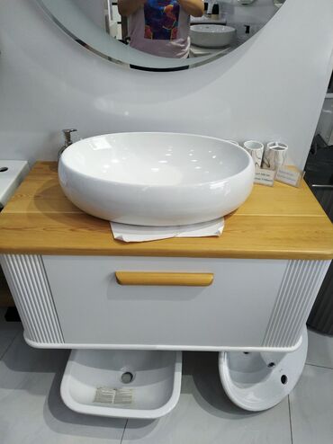hamam kuncluyu: Ağ rəngdə, dəyirmi formalı keramik lavabo. Lavabo açıq rəngli, taxta