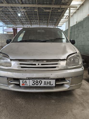 Toyota: Автомобиль Toyota Raum серебристого цвета. Это компактный минивэн с