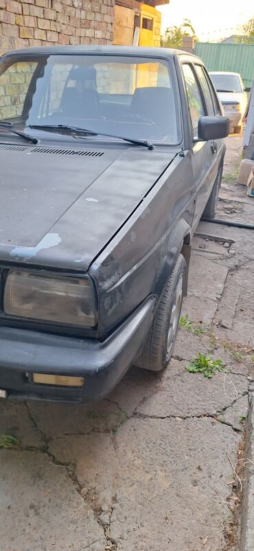 женил жук ташуучу унаа: Автомобиль Volkswagen Jetta серого цвета, седан. Оснащен передними
