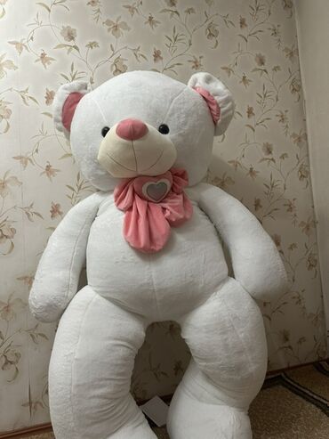 Игрушки: Большой белый плюшевый медведь с розовым носом и розовым бантом в виде