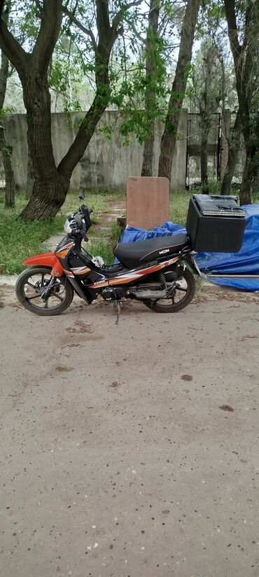 Oranj və qara rənglərdə olan bu motosiklet, rahatlıq və funksionallıq