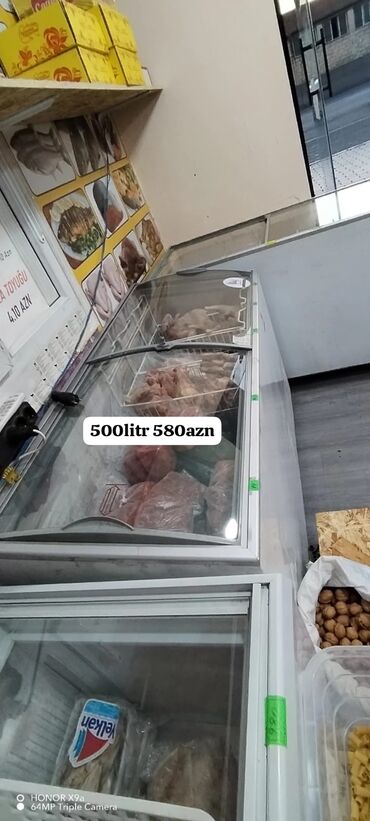 Qabyuyan maşınlar: Şəffaf sürüşmə qapaqları olan ağ rəngli ticarət dondurucusu. Bu