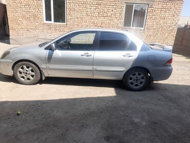 аутлендер оутлендер аиртрек айртрек: Серебристый седан Mitsubishi Lancer с четырьмя дверями и