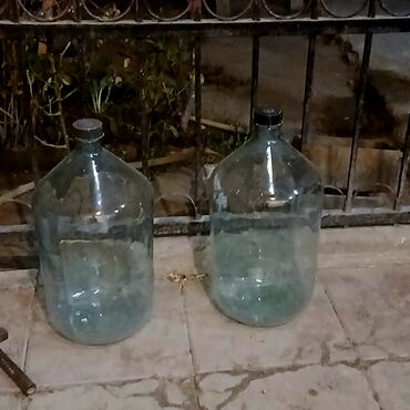 Yemək konteynerləri: Şəffaf şüşədən hazırlanmış, qara plastik qapaqlı iki iri şüşə balon