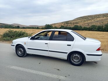 Ağ rəngli sedan tipli avtomobil. Avtomobilin eksteryeri sadə dizayna