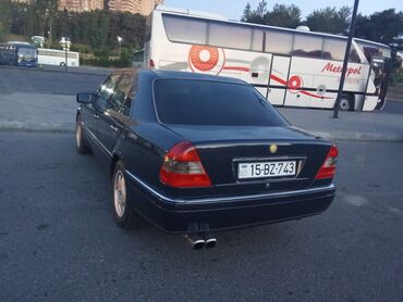Tünd göy rəngdə, dördqapılı sedan görünüşlü avtomobil. Arxa hissəsində